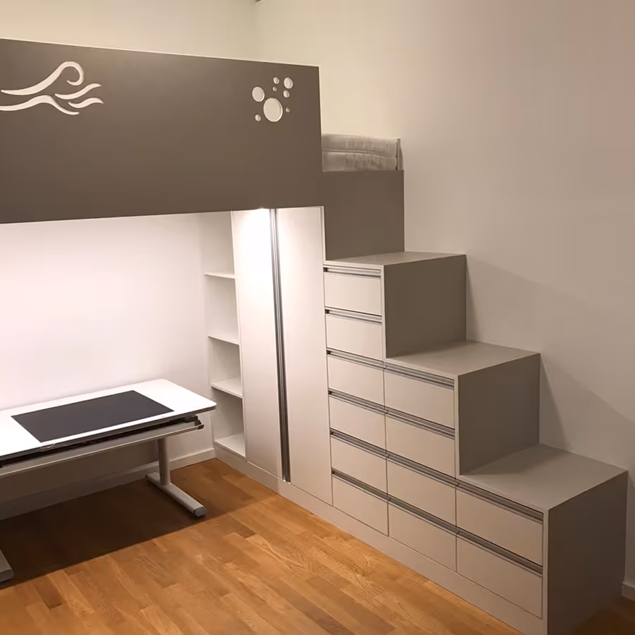 Modernes Kinderhochbett mit integrierten Treppen und Schubladen, darunter ein weißer Schreibtisch auf Holzboden.