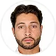 Man with dark hair and beard wearing a white shirt on a white background.