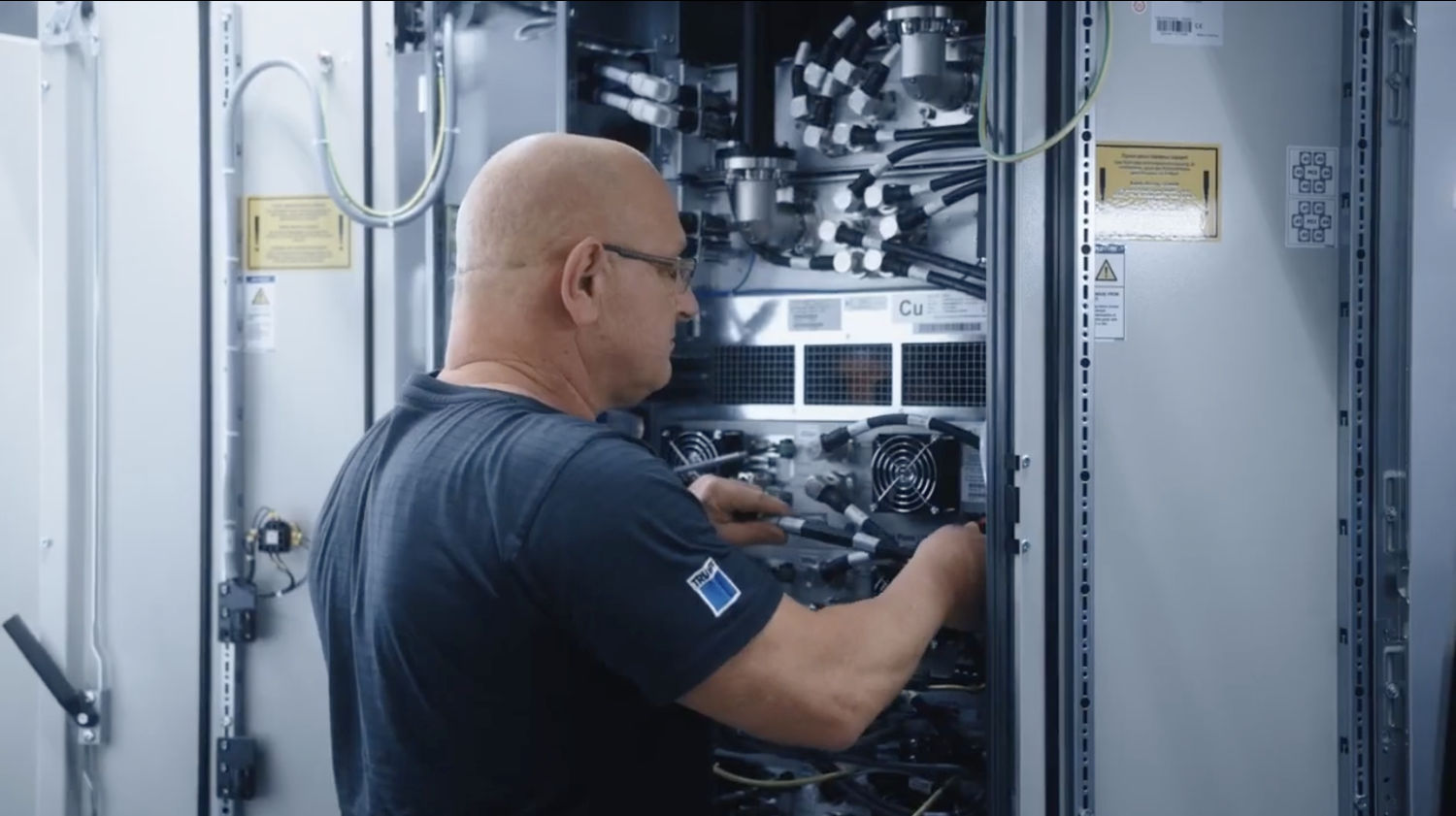 Techniker arbeitet an der Verkabelung im Inneren eines Hochfrequenz-Generators von TRUMPF Hüttinger