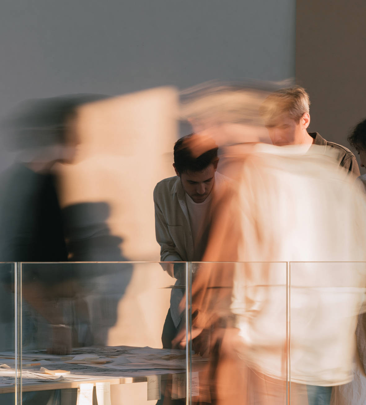 Stimmungsbild: unscharfe Personen begutachten Unterlagen an einem Tisch