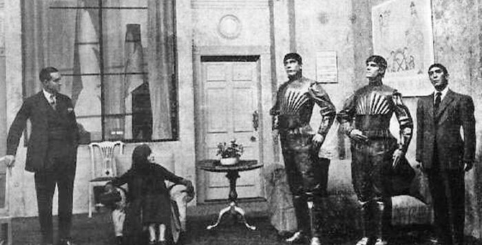 Scene from a 1920s stage production of Karel Čapek's R.U.R. with two actors in robot costumes