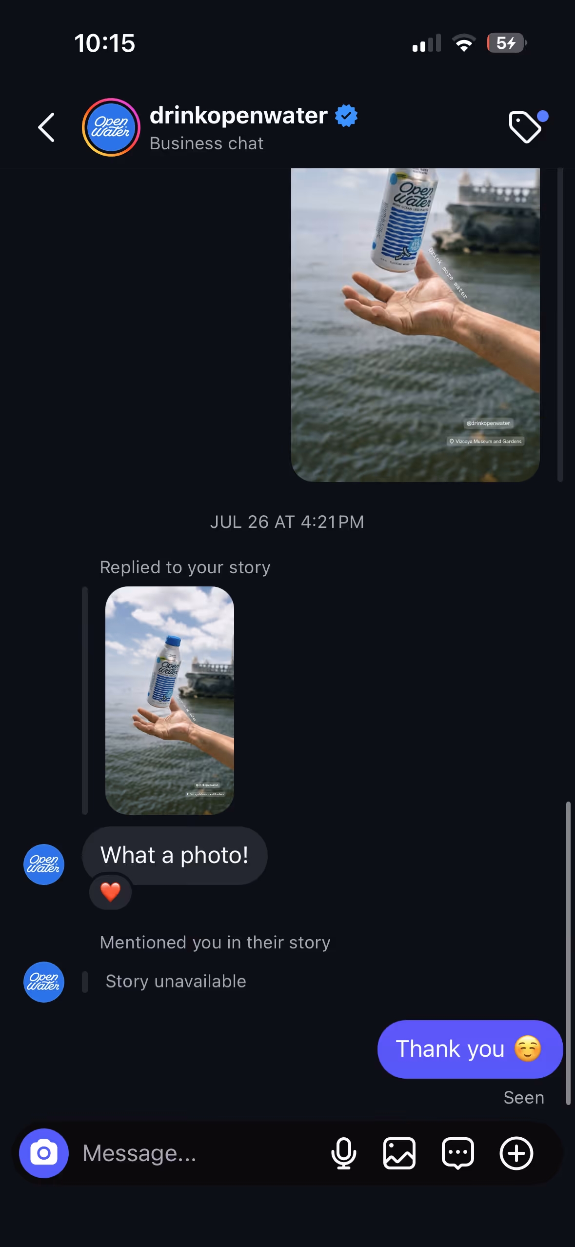 A screenshot of an Instagram direct message conversation where the brand "Open Water" praises a shared photo of their product with the message, "What a photo!"
