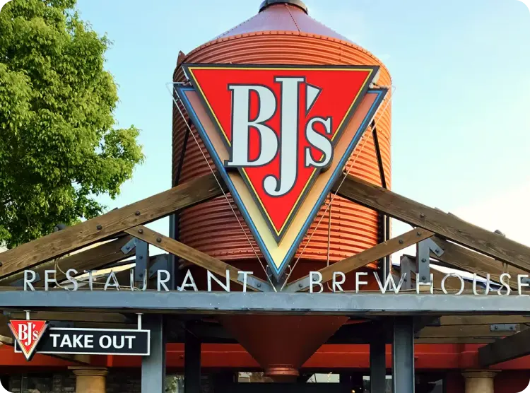 BJ's Restaurant Brewhouse exterior with the signature red brew tank and sign above the entrance.