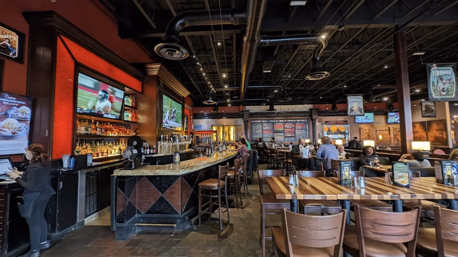 Guests and staff at the bar and dining room inside a BJ's Restaurant & Brewhouse during service.