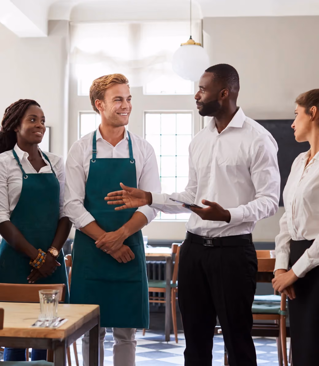 Restaurant manager briefing a team of servers before service.