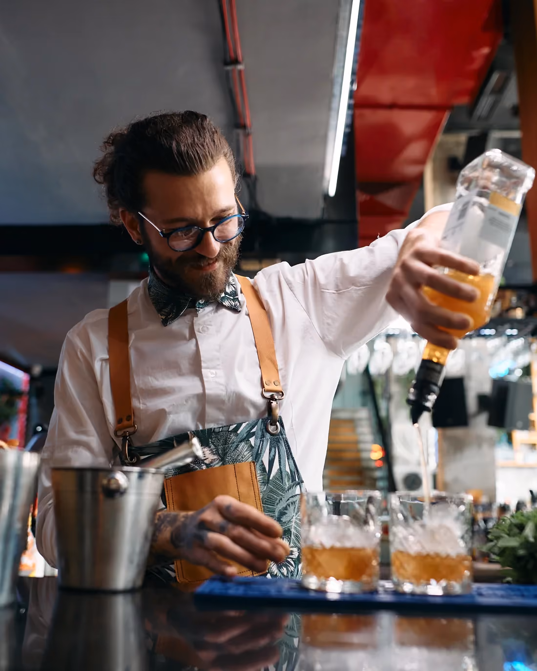 Bartender pouring a cocktail on a shift that ends with an instant digital tip payout.