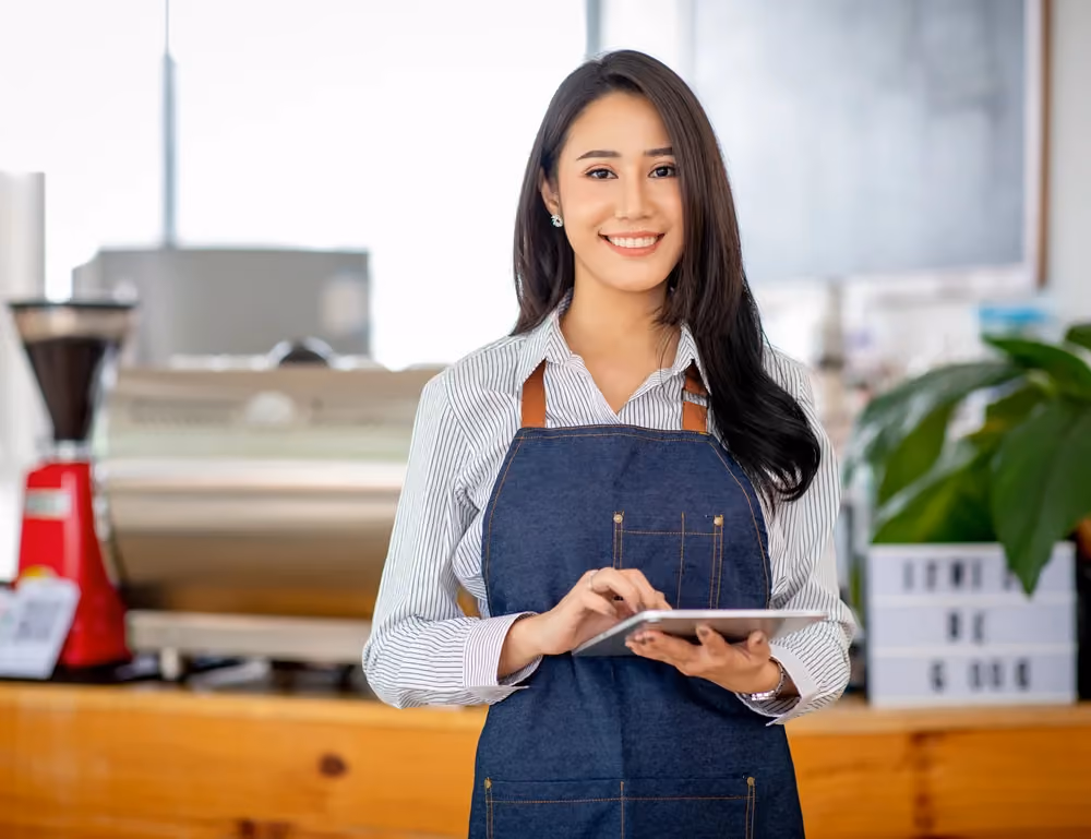 Restaurant staff member checking earned wages on a tablet before payday.