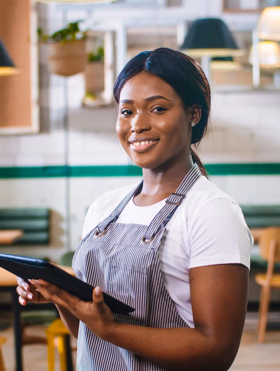 Restaurant staff member reviewing her tip share on a tablet at the pass.