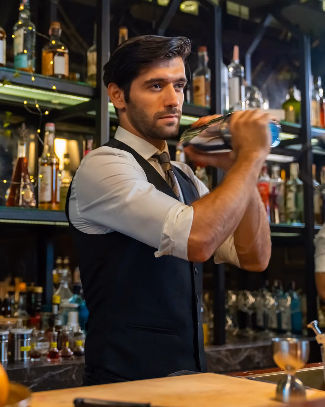 Bartender mixing a cocktail in a fine dining restaurant where the whole house shares the tip pool.