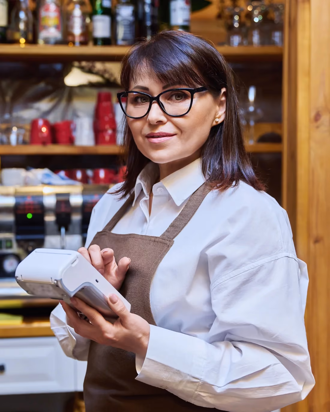Hospitality staff member with a payment terminal at a hotel bar, one of several departments sharing tips.