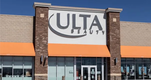 Exterior view of an Ulta Beauty store with large sign above entrance and orange awnings.