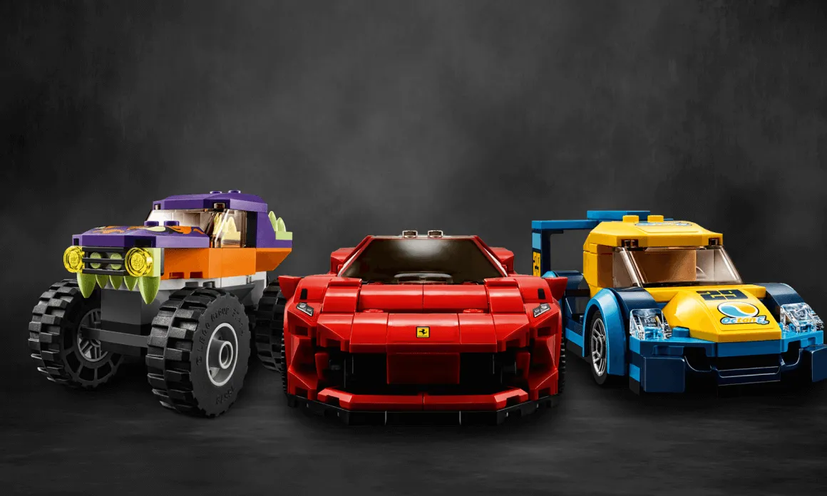 Three Lego cars displayed side by side: a purple and orange monster truck on the left, a red sports car with a Ferrari logo in the center, and a blue and yellow race car on the right.