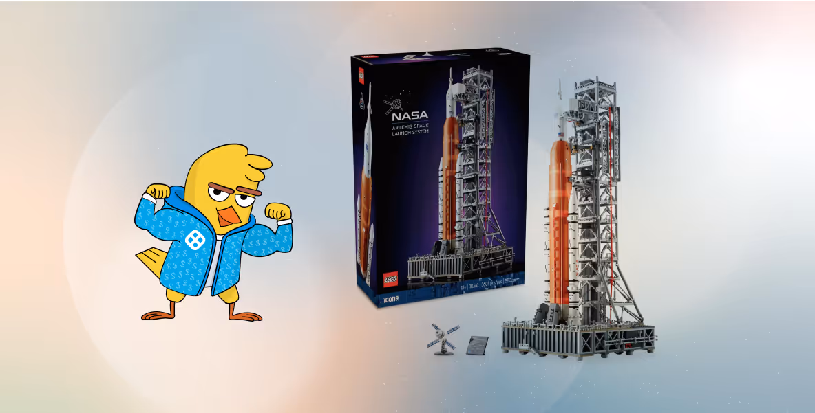 LEGO NASA Artemis Space Launch System kit with rocket model, launch tower, and accessories, alongside a cartoon bird flexing muscles in a blue jacket.