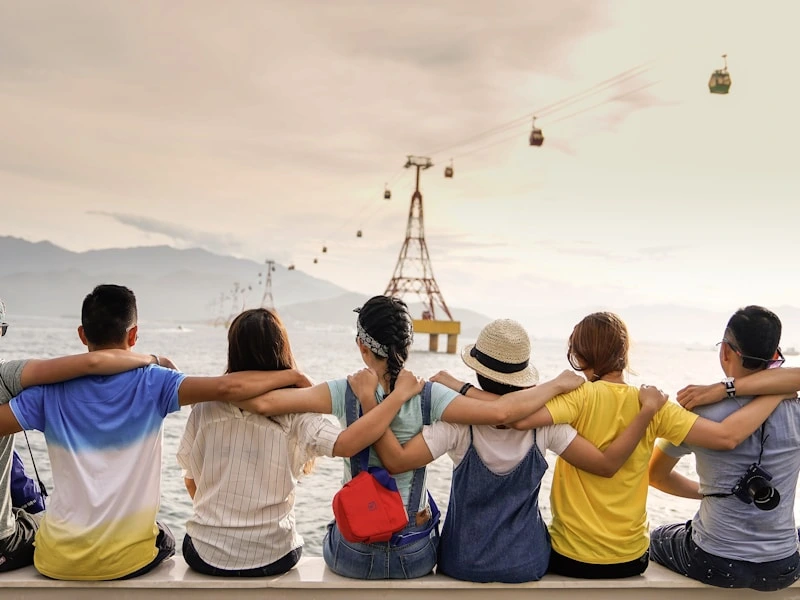 Group of friends sitting together overlooking a mountain cable car view