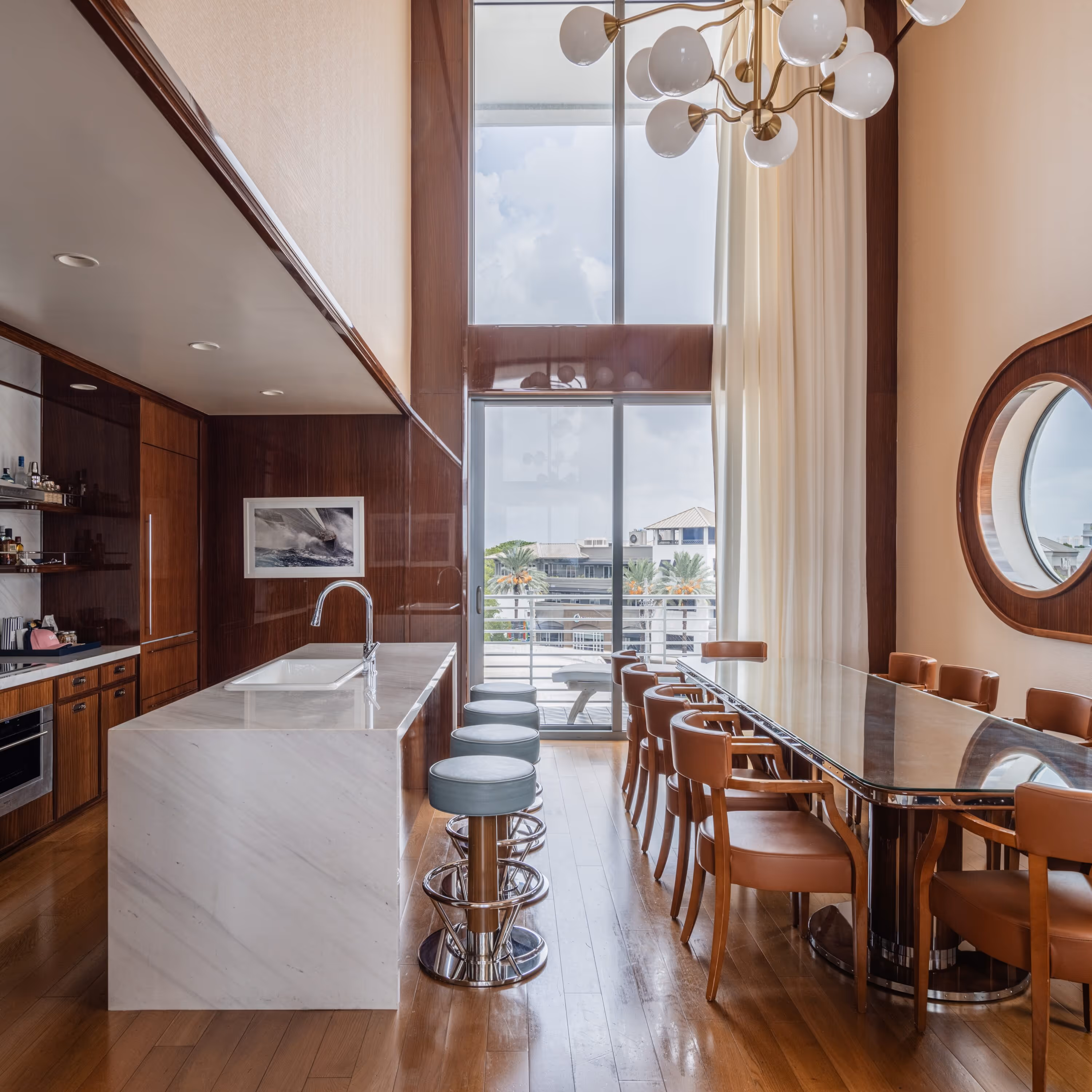 Área de jantar com uma mesa grande e ilha de cozinha no Mr. C Miami – Coconut Grove, um hotel de luxo em Miami.