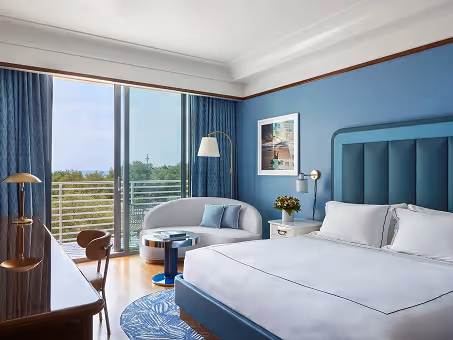 Quarto de hotel com cama king, mesa de trabalho, sofá e varanda ampla com vista. Mr. C Miami – Coconut Grove, um hotel de luxo.