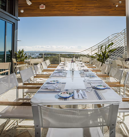 Sunny dining setup at Bellini with water views. Mr. C Miami – Coconut Grove, a luxury hotel.