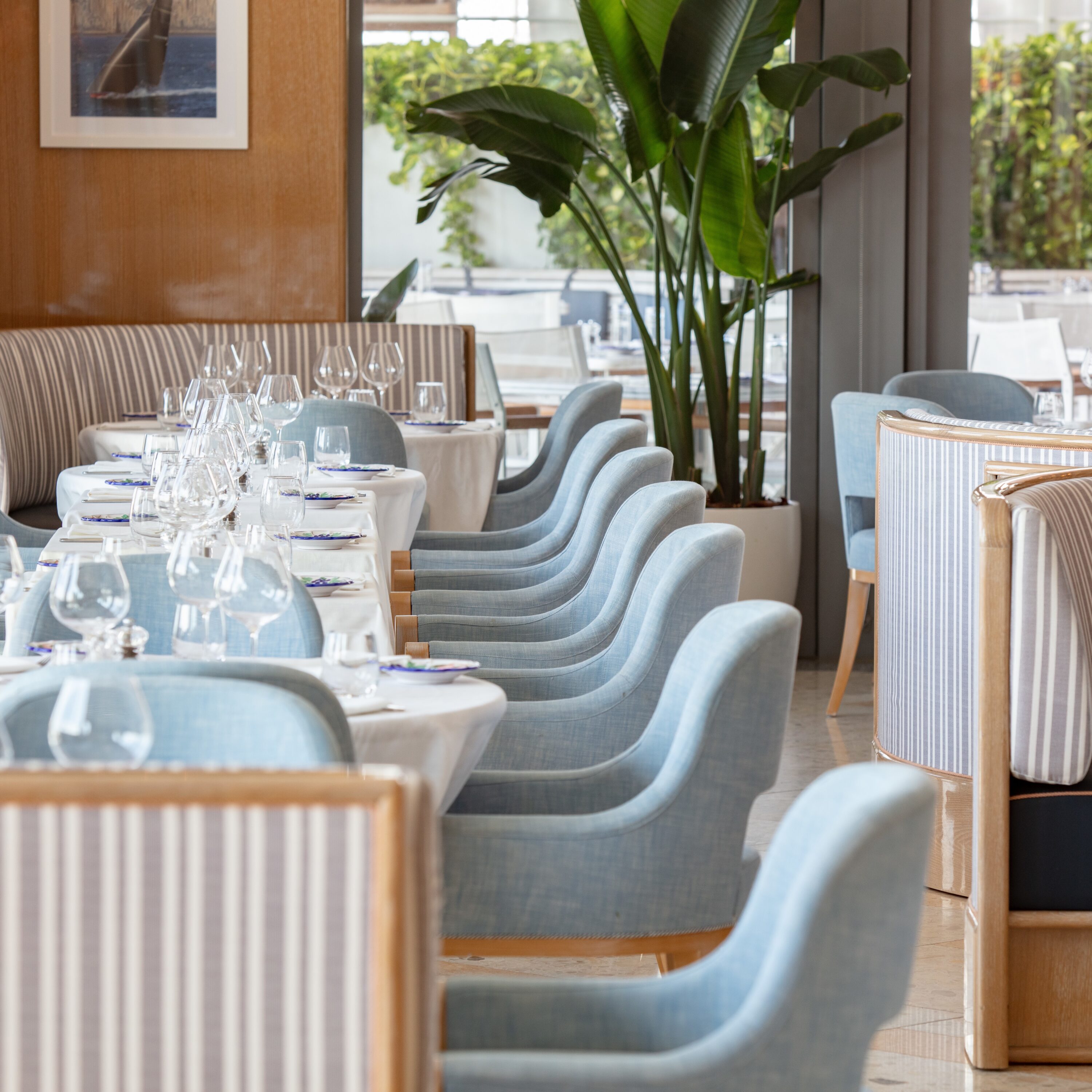 Rangées de chaises bleues et rayées avec des nappes blanches dressées avec des assiettes et des verres, Mr. C Miami – Coconut Grove, hôtel de luxe.