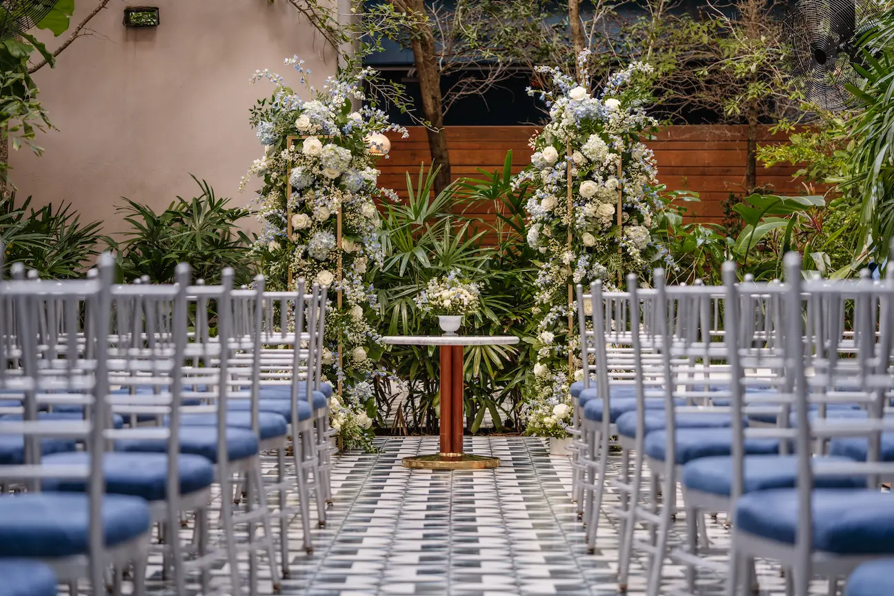 Elegant outdoor wedding ceremony setup at Il Giardino with floral arches and chairs. Mr. C Miami – Coconut Grove.