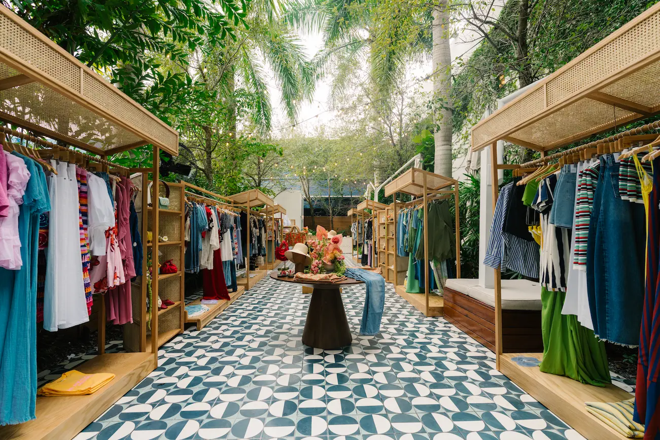 Stylish outdoor boutique setting at Il Giardino with clothing racks on a patterned tile terrace. Mr. C Miami – Coconut Grove.