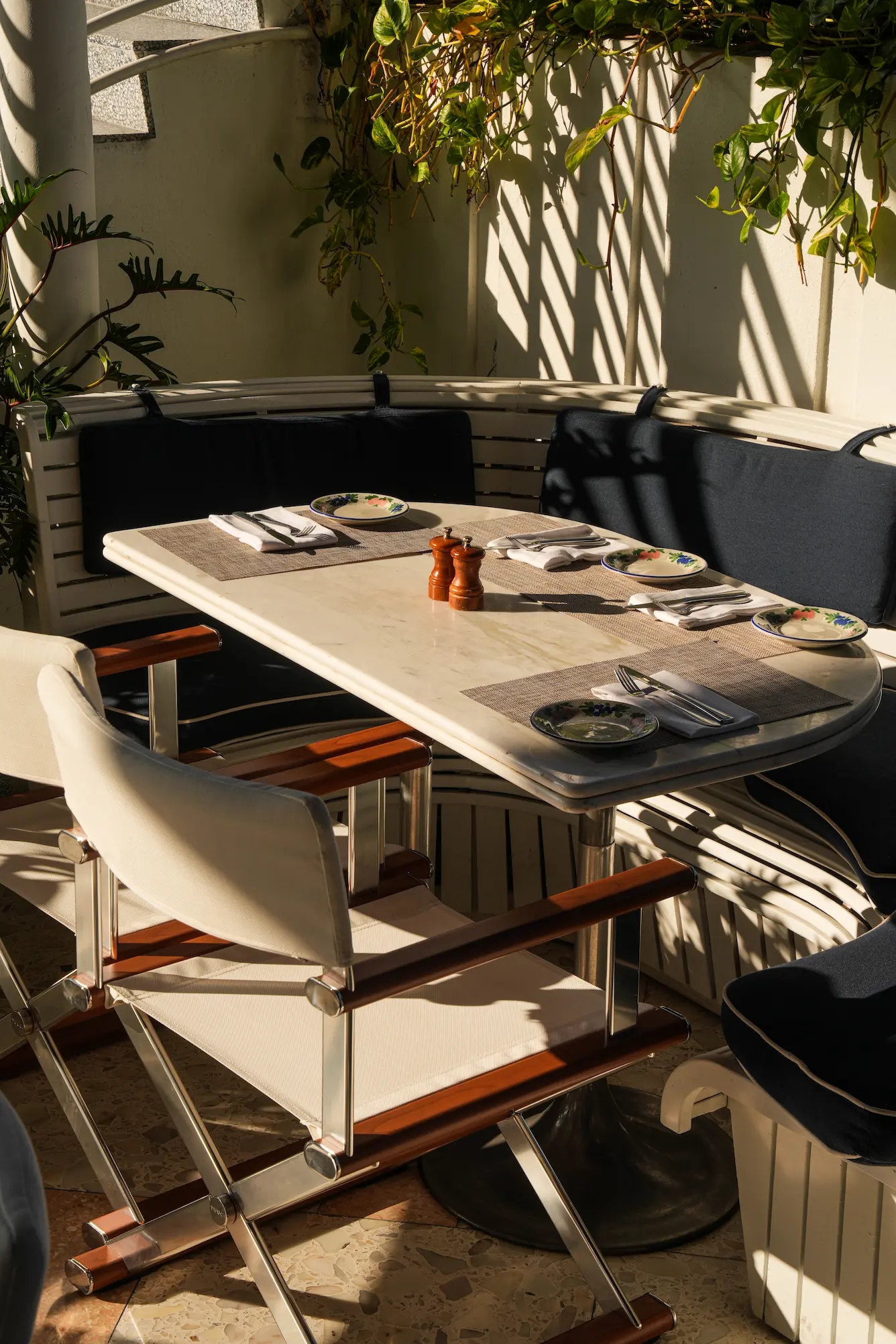 Intimate dining table set for two on the cozy, shaded Bellini patio. Mr. C Miami – Coconut Grove, a luxury hotel.