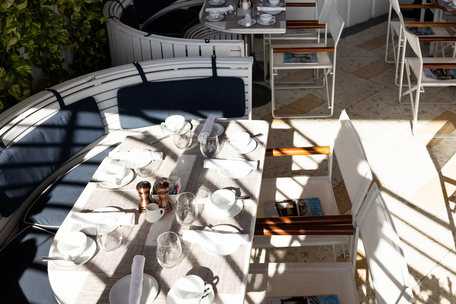 Outdoor seating area at Bellini featuring a curved bench and tables. Mr. C Miami – Coconut Grove, luxury hotel.