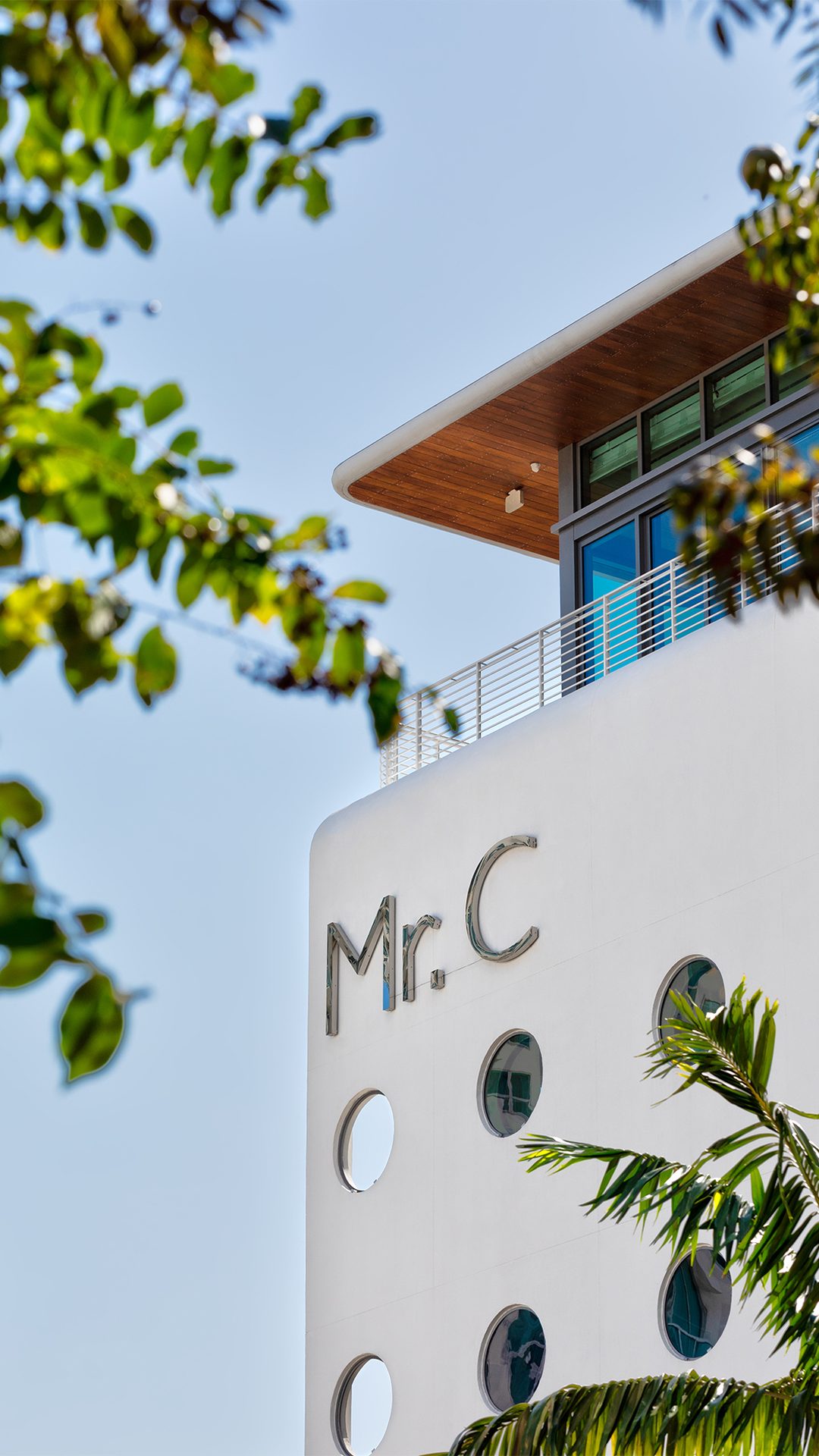 Extérieur de l'hôtel vu à travers des palmes tropicales au Mr C Coconut Grove, hôtel de luxe dans le sud de la Floride