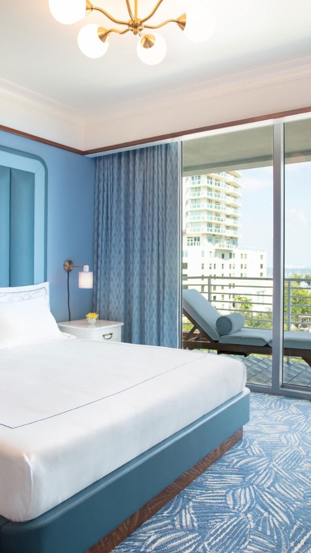 Chambre d'hôtel avec lit king-size et balcon privé donnant sur la skyline au Mr C Coconut Grove, hôtel de luxe à Miami