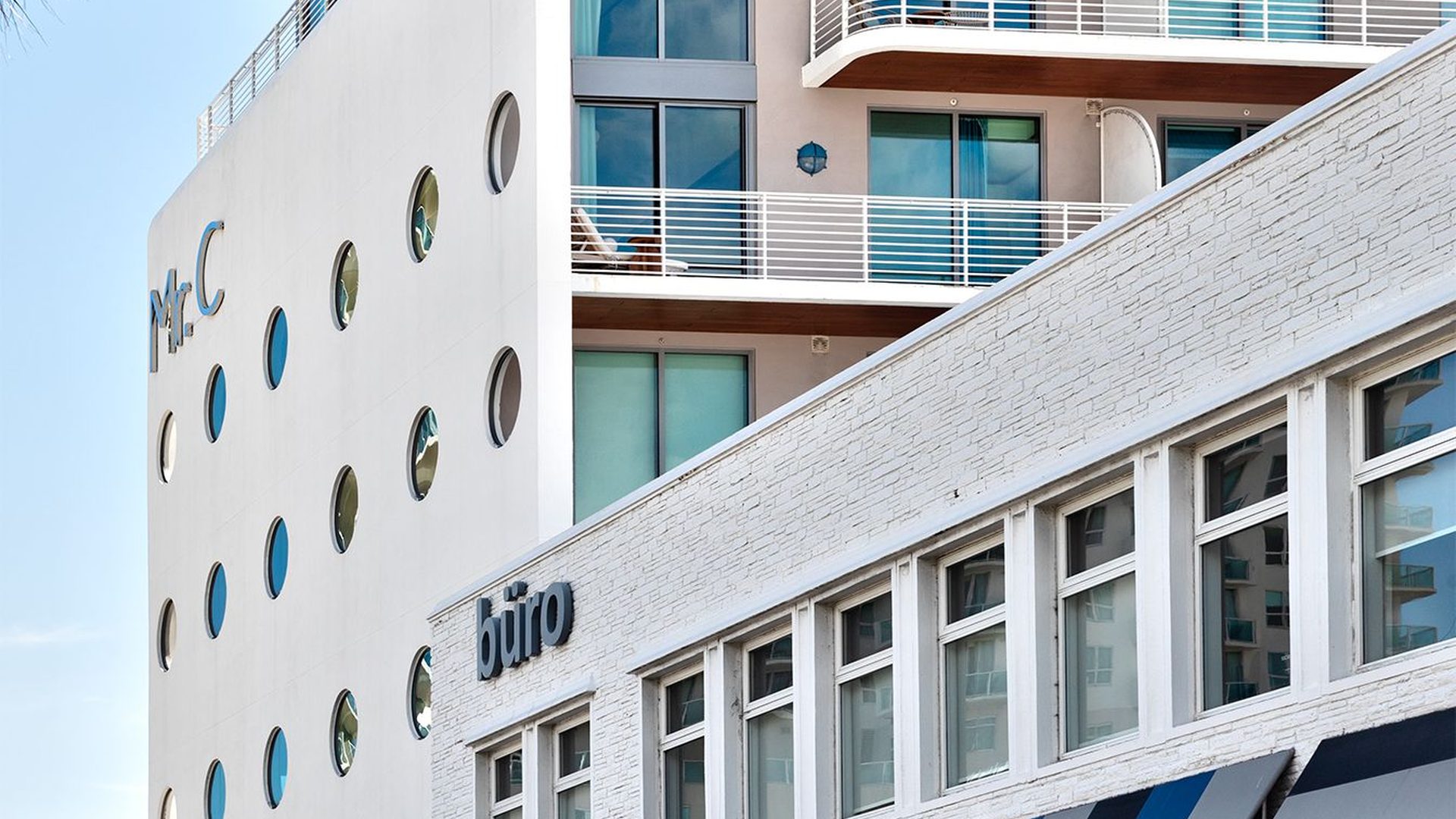 Edificio dell'hotel con balconi a gradoni e tettoia panoramica sopra le boutique del quartiere al Mr. C Coconut Grove, hotel di lusso nel sud della Florida