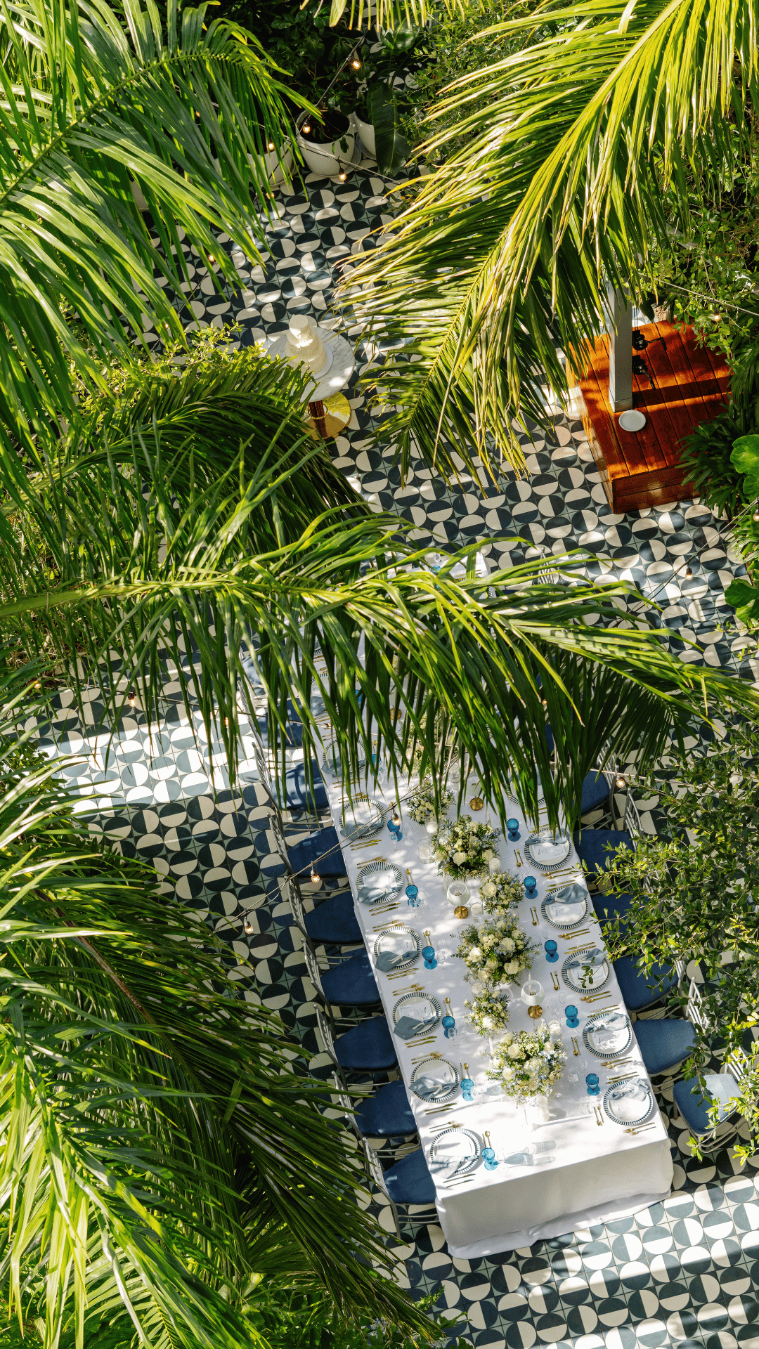 Tavola apparecchiata all'aperto con fiori bianchi in un rigoglioso cortile giardino al Mr. C Coconut Grove, hotel di lusso a Miami