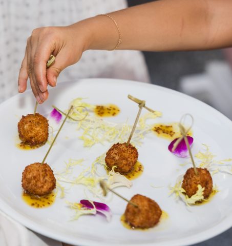 Cameriere che serve un piatto di crocchette croccanti al Mr. C Coconut Grove, hotel di lusso nel sud della Florida