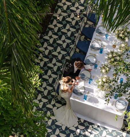 Veduta aerea di sposi seduti a un elegante tavolo da ricevimento presso Mr. C Coconut Grove, hotel di lusso nel sud della Florida