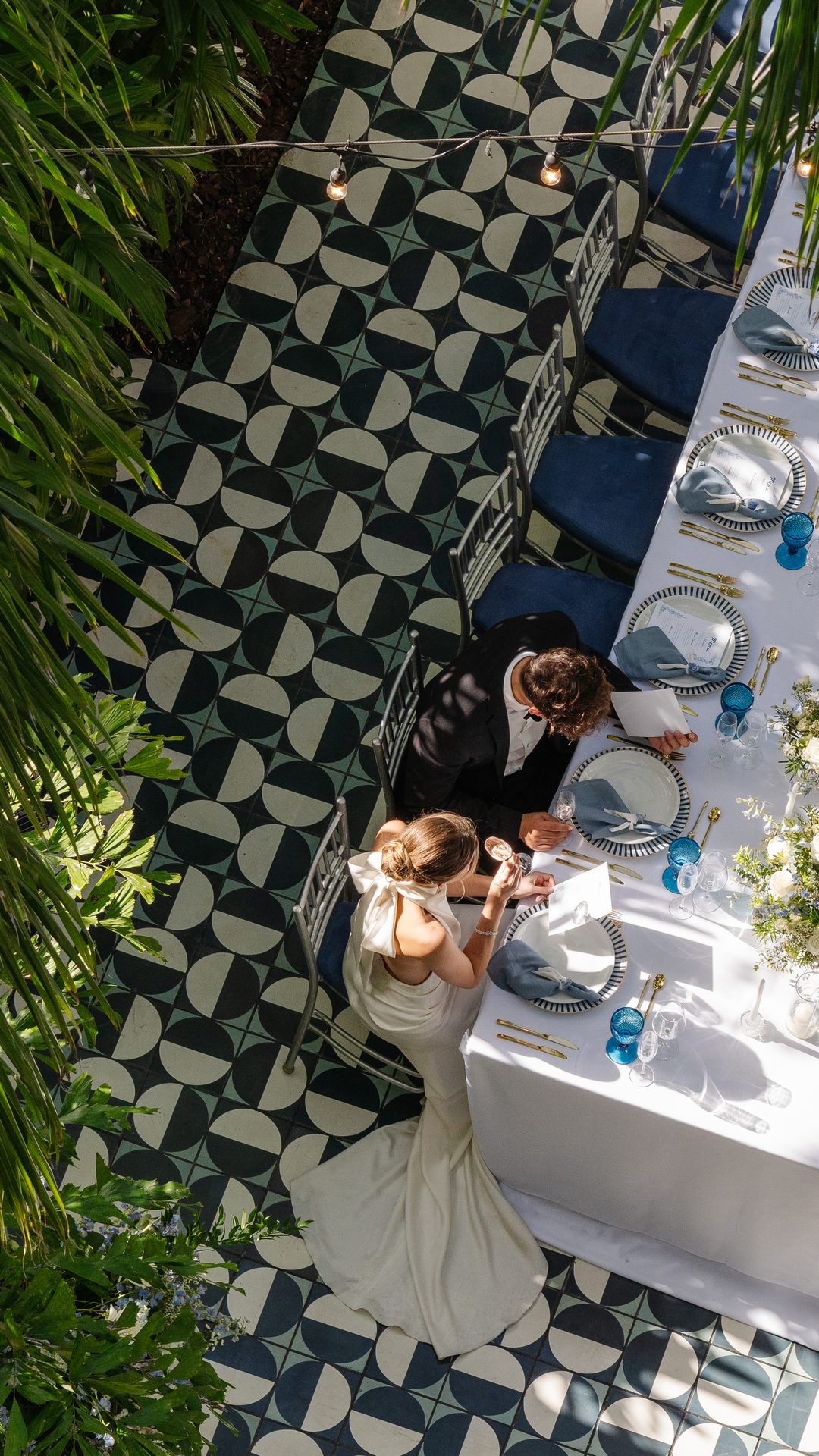 Sposi a cena sotto le palme a un tavolo decorato con fiori presso Mr. C Coconut Grove, hotel di lusso a Miami
