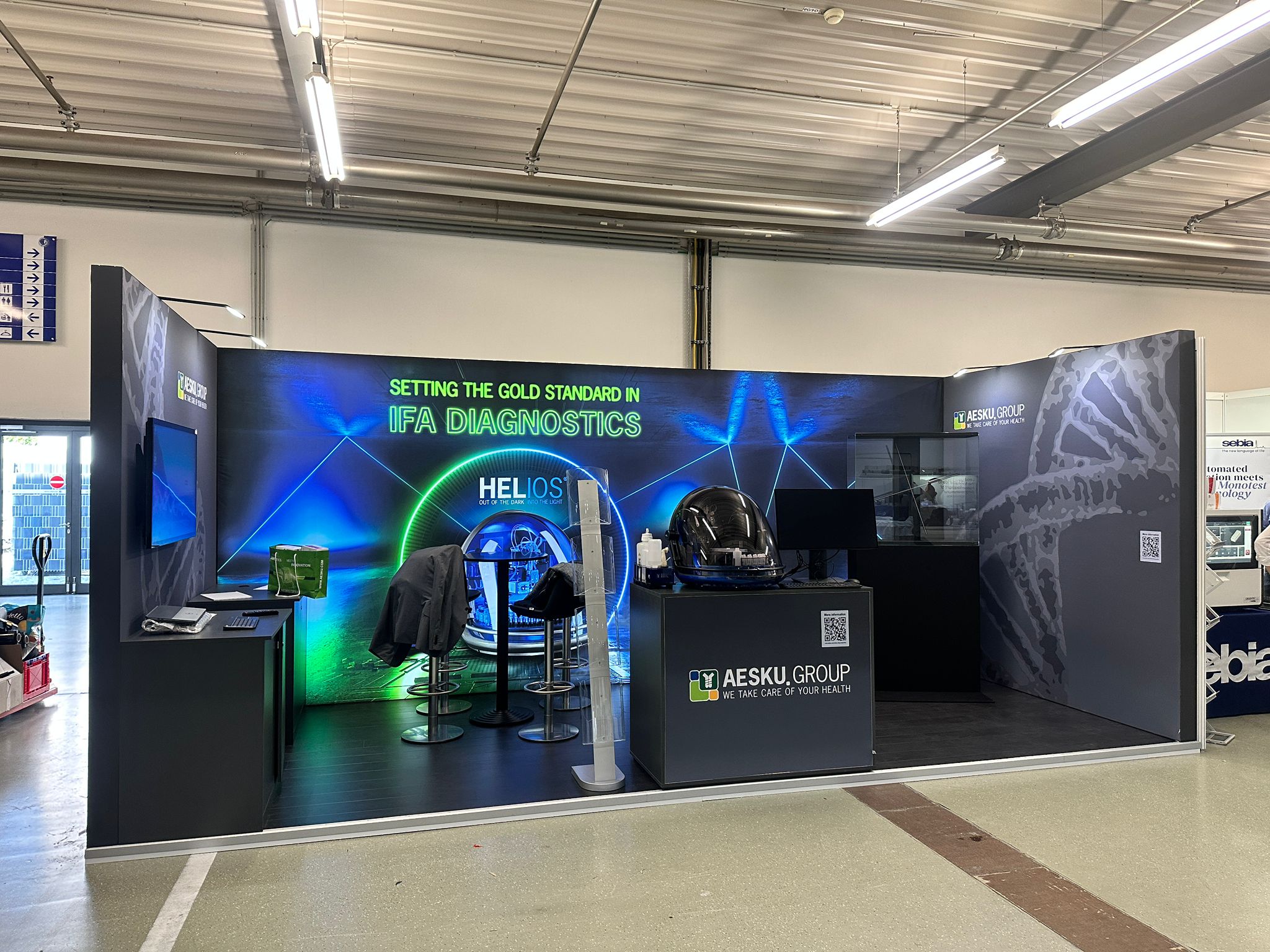 Medical technology exhibition stand with digital displays and meeting area