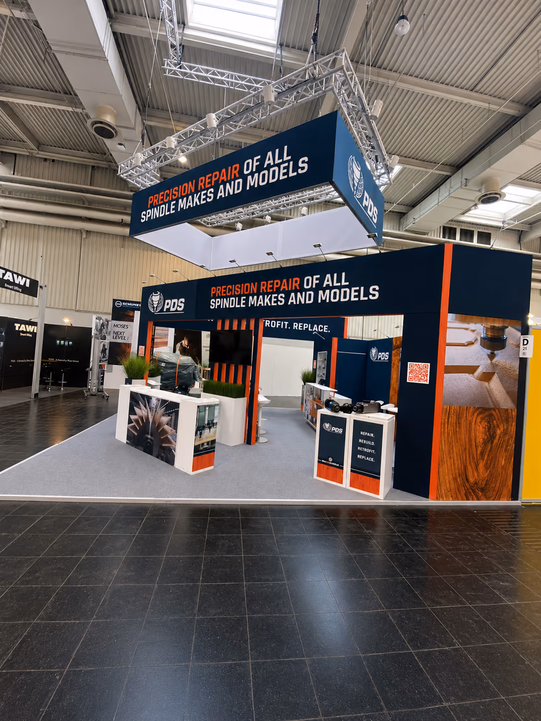 PDS exhibition booth with orange and black branding and meeting area