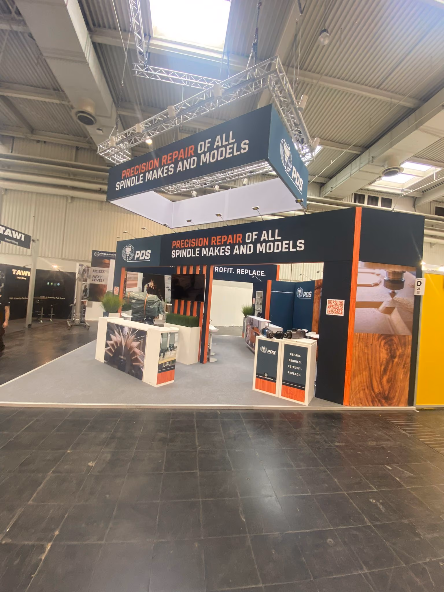 PDS exhibition booth with orange and black branding and meeting area