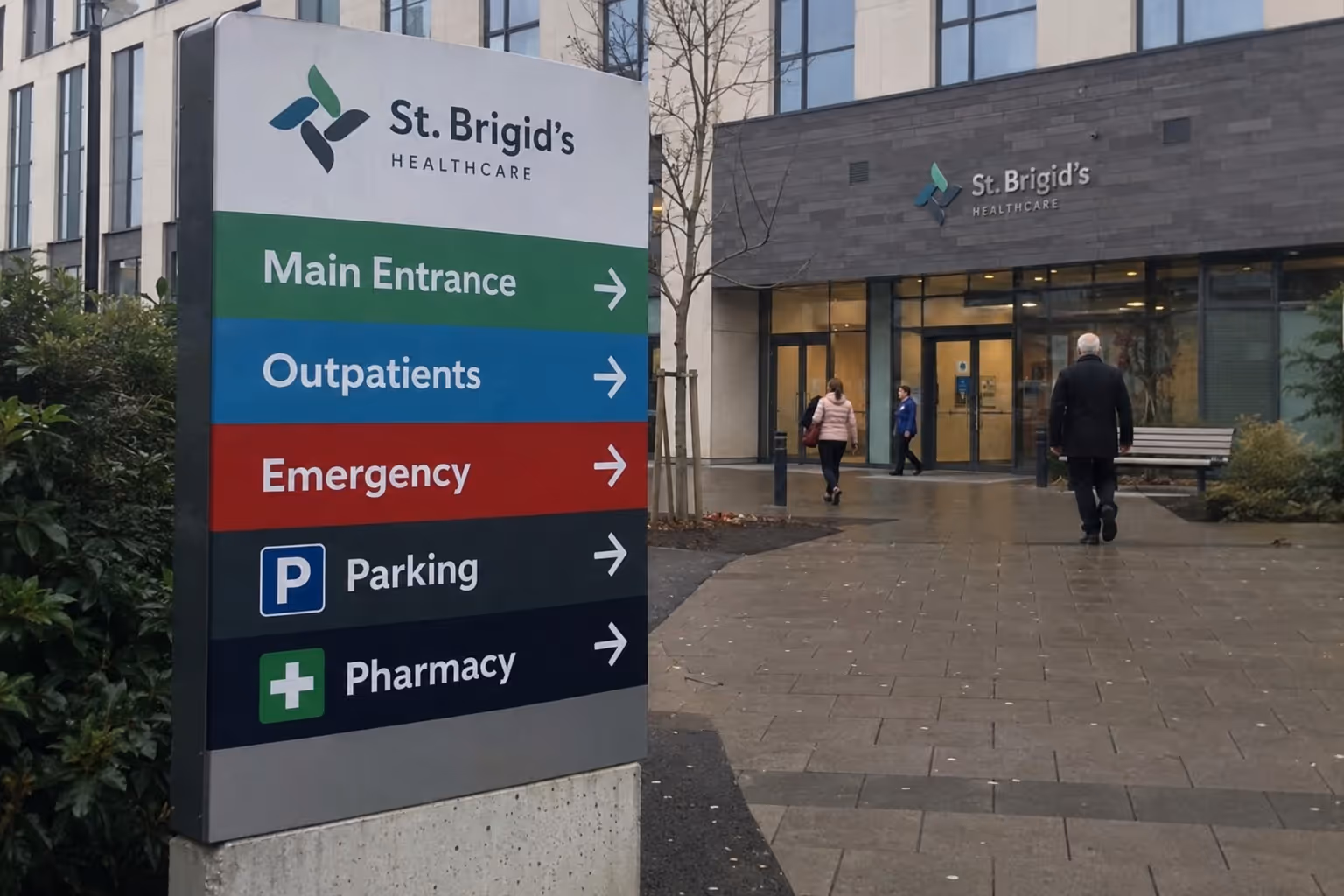 Directional sign outside St. Brigid's Healthcare with arrows for entrance, outpatients, emergency, parking, pharmacy.