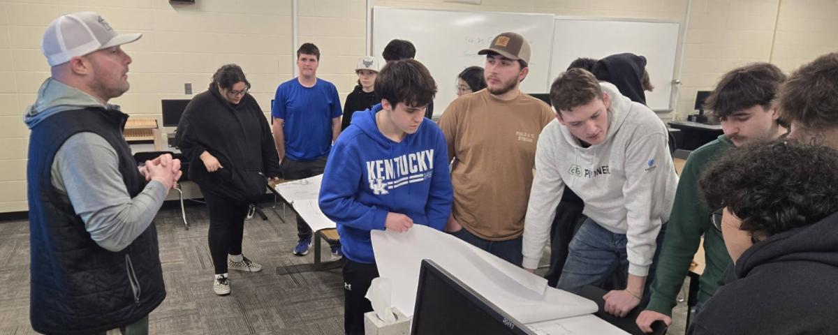 Power Truss Vice President Brad Power presenting to ATC advanced carpentry students reviewing blueprints during a Power in Partnership classroom visit