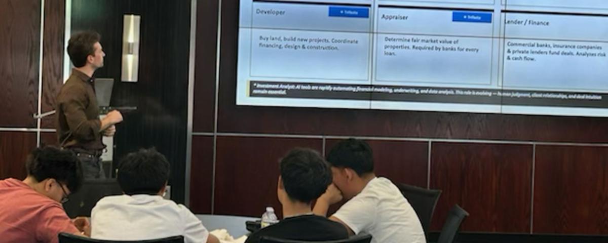 A local business professional presenting career opportunities in architecture and real estate to high school students during a Community Connections field trip