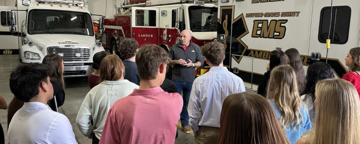 High school students listening to a presentation at a fire station during a Community Connections healthcare career field trip