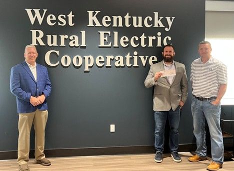Jason Lemle accepting donation from WKRECC president & CEO David Smart and Board Treasurer Jed Clark