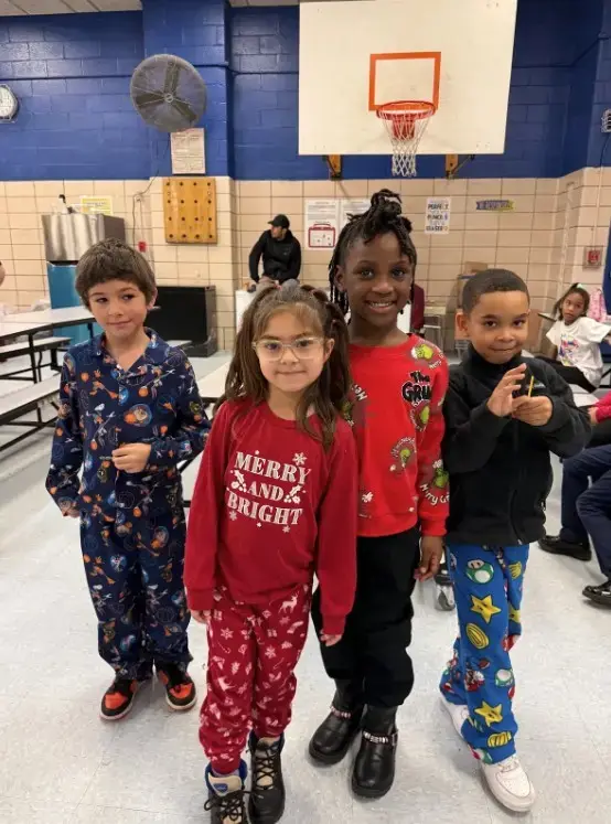 Four students wearing festive pajamas during school holiday spirit day