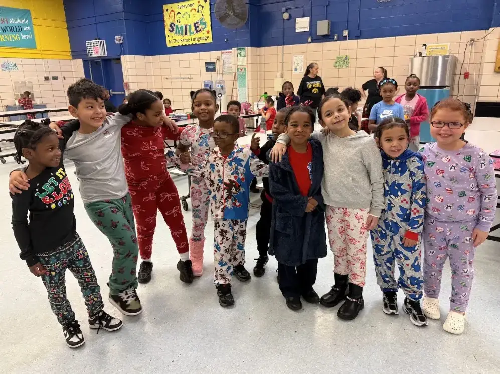 Students wearing pajamas smile together during school pajama day