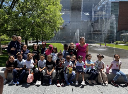 Students and teacher posing outside a museum on field trip