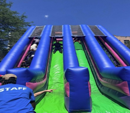 Students sliding down a large inflatable slide at school event