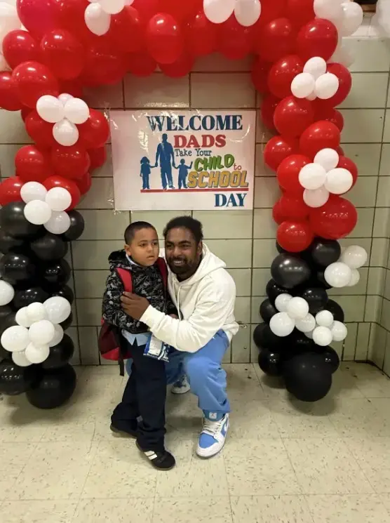 Dad and child posing at Take Your Child to School Day event