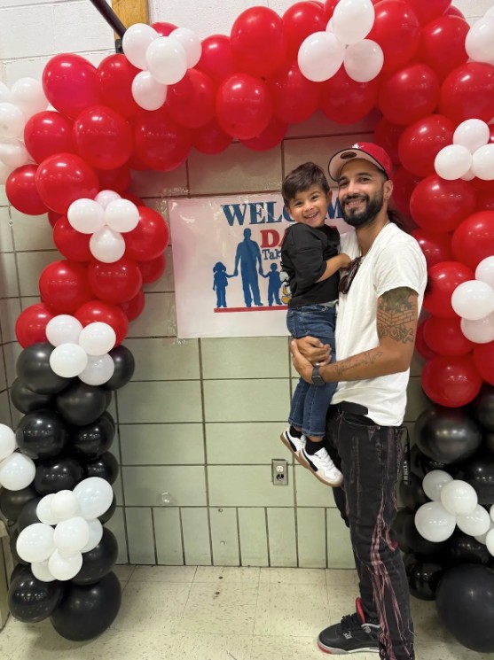 Father holding child at school Take Your Dad to School event