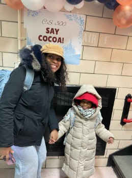 Adult and child in winter coats at CS 300 Say Cocoa event