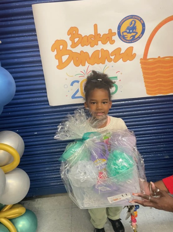 Student holding a prize basket at the school Basket Bonanza event