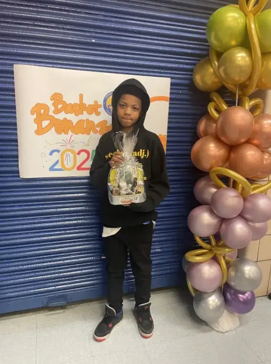 Student holding gift basket at Basket Bonanza 2025 school event
